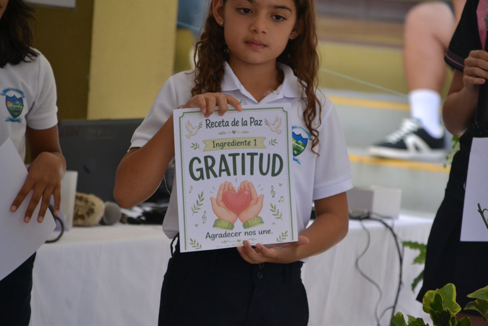 Young participant holding a “Gratitude” sign during a school peace activity at Choral Fest Costa Rica.