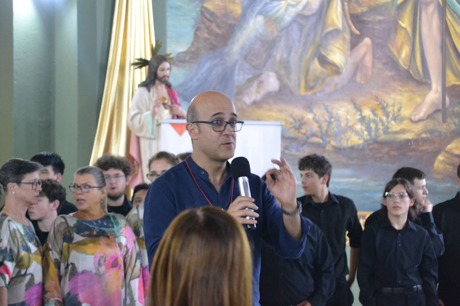 Presenter speaking with a choir in a church during Choral Fest Costa Rica for Peace.