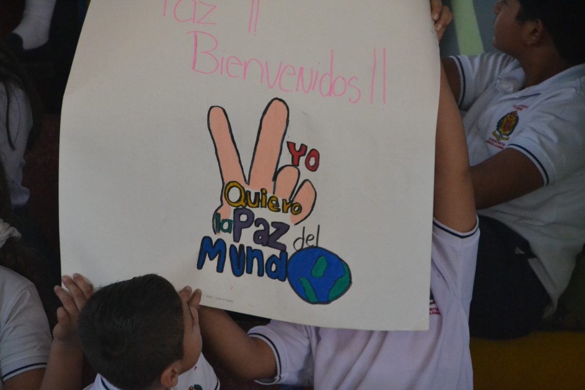 Niños sostienen un cartel sobre la paz durante una actividad comunitaria de Choral Fest Costa Rica por la Paz.