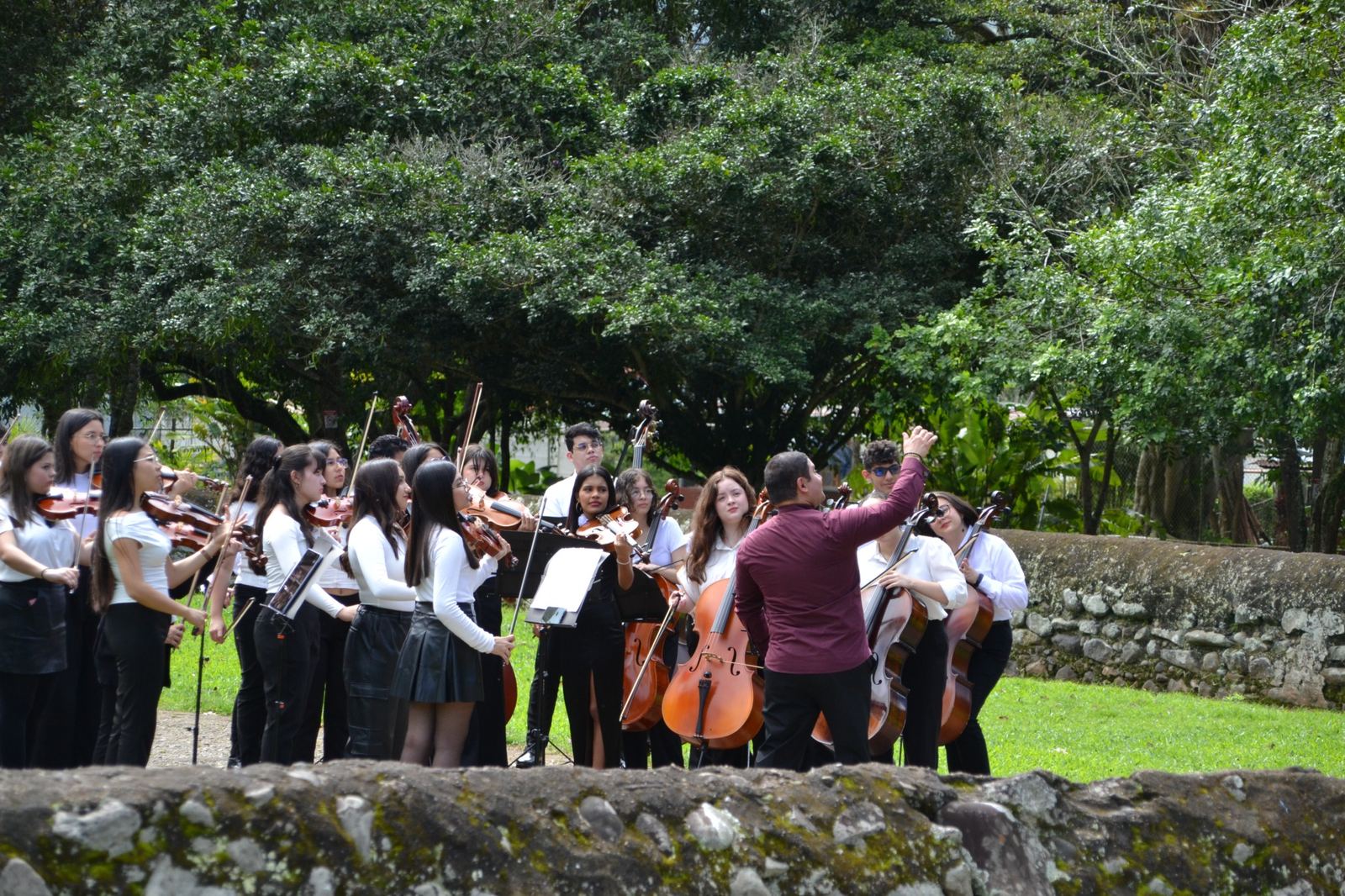 Youth orchestra performing outdoors during Choral Fest Costa Rica for Peace, representing artistic growth, cultural exchange and shared purpose.