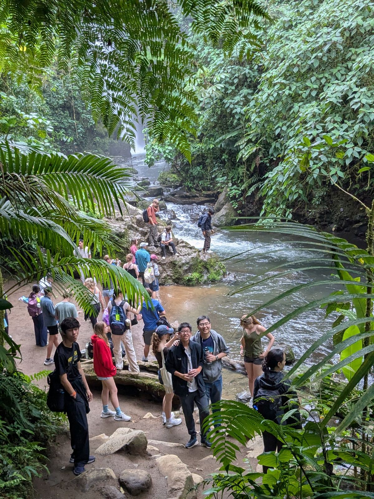 Choir travelers exploring a rainforest waterfall in Costa Rica during a meaningful cultural and nature experience.