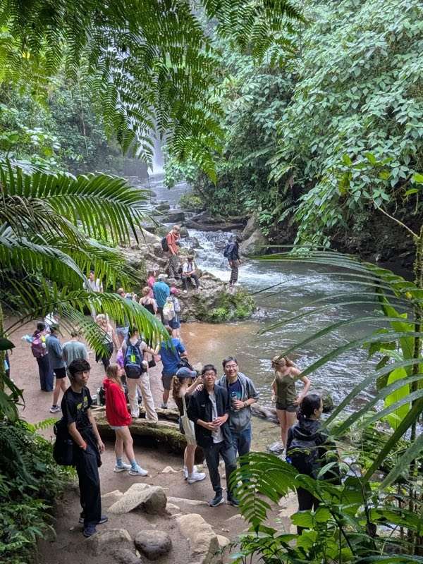 Choir travelers exploring a rainforest waterfall in Costa Rica during a meaningful cultural and nature experience.